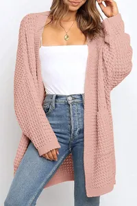 Detalle de un cárdigan rosa de punto grueso con mangas largas y bolsillos laterales