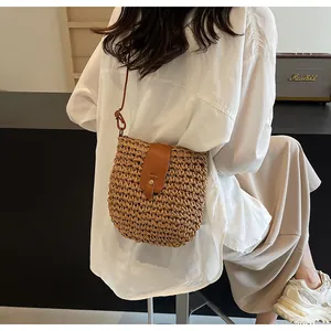 Detailansicht einer gewebten Stroh-Eimertasche im Urlaubsstil als Umhängetasche.