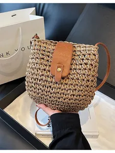 Trendige handgewebte Eimertasche aus Stroh mit einem schmalen braunen Lederriemen