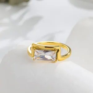 Close-up detail of a minimalist gold-plated ring with a rectangular clear zircon stone