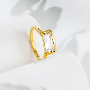 Close-up detail of a minimalist 18k gold ring with a sparkling square zirconia stone