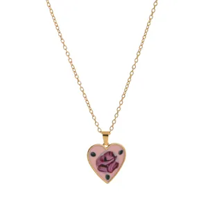 Vintage gold chain necklace featuring a pink enamel heart pendant with a purple rose