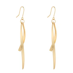 Detailed macro view showing the smooth texture of minimalist gold-tone twisted geometric drop earrings.
