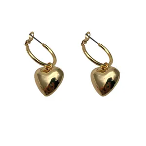 Close-up macro detail showing the polished finish of elegant gold heart hoop earrings