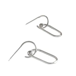 Detail view of simple silver-colored geometric oval link earrings with hooks.
