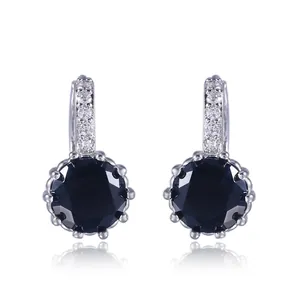 Detail showing elegant minimalist silver hoop earrings featuring large round black gemstones