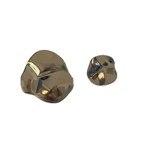 Close-up of unique gold irregular geometric metal earrings with textured finishes