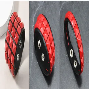 Nahaufnahmen von rotem Lederarmband mit Pyramidennieten im Punk-Stil und Druckknöpfen