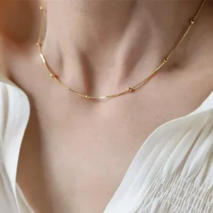Detaillierte Makroansicht einer eleganten minimalistischen Goldperlen Schlangenkette