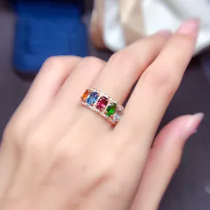 Gros plan d'une bague en or rose avec cinq pierres colorées et des accents de zircon