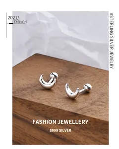 Detailed view of S999 sterling silver crescent moon screw-back stud earrings on wooden base.