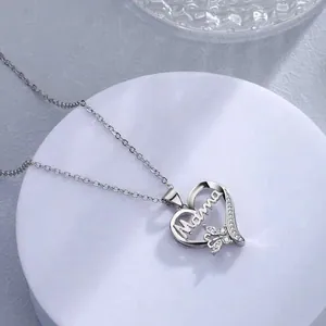 Detailed view of silver heart pendant with 'Mama' script and butterfly detail