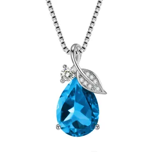 Macro view of silver blue teardrop gemstone necklace with diamond-set leaf detail
