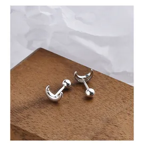 Detailed macro view of silver crescent moon stud earrings with screw-on ball back