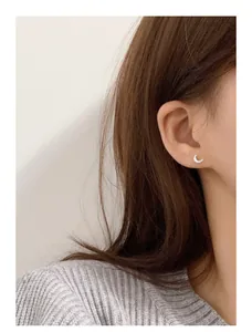 Detail showing 999 sterling silver crescent moon stud earring worn on model's ear
