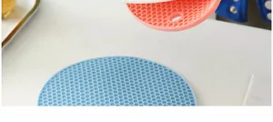 Gros plan de dessous de plat en silicone nid d'abeille bleu et rose.