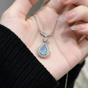 Close-up macro view of mermaid teardrop aquamarine pendant with a sparkling pavé halo
