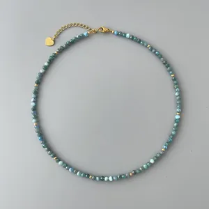 Vista dettagliata di una collana di perline in pietra naturale blu con ciondolo a cuore oro.