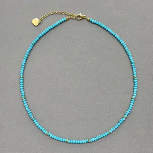 Dettaglio di collana di perline turchesi con ciondolo a cuore e catena placcati in oro 18k.