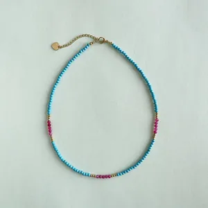 Elegante collana di perle con pietre blu turchese e rosa e accenti in oro 18 carati.
