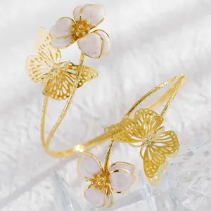Detailed close-up of an elegant gold butterfly and flower adjustable cuff bracelet.
