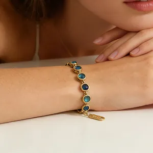 Gros plan d'un bracelet vintage en or 18 carats orné de zircons bleus dégradés sur le poignet.