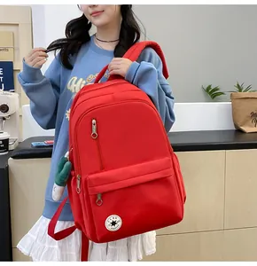 Large red minimalist school backpack with multiple compartments shown on a model