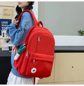 Side view of a bright red large capacity nylon backpack worn by a student model