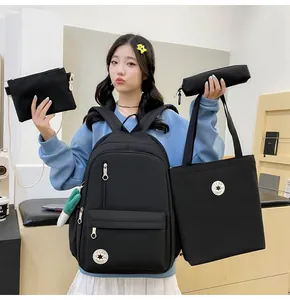 Model holding 4-piece black student backpack set in Korean minimalist style