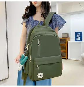 Detail view of a stylish green large capacity student backpack worn by a female model