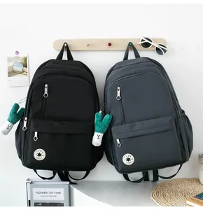 Detailed view of two minimalist student backpacks in black and grey hanging on a wall