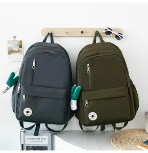 Minimalist student backpacks in dark grey and olive green shown in lifestyle scene