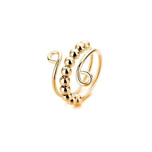 Anillo antiestrés dorado con cuentas giratorias y diseño en espiral relajante