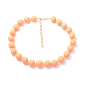 Λεπτομερής προβολή κολιέ με ροδακινί στρογγυλές χάντρες και χρυσή αλυσίδα
