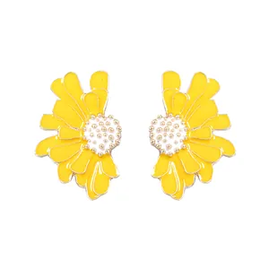 Vue détaillée montrant la finition en émail jaune vif et le centre doré des boucles d'oreilles