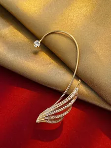 Close-up of elegant gold-tone leaf ear cuff with sparkling zircon accents