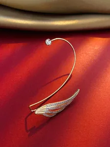Detail view of a gold-tone angel wing ear cuff with sparkling cubic zirconia stones