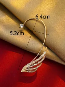 Detailed macro view of elegant gold leaf ear cuff with cubic zirconia and size markings