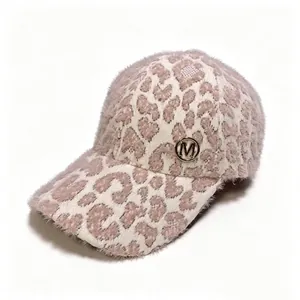 Close-up detail of a soft leopard print plush baseball cap with a metallic M logo.