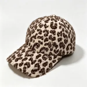 Detailed texture of a leopard print plush warm baseball cap with M metal logo