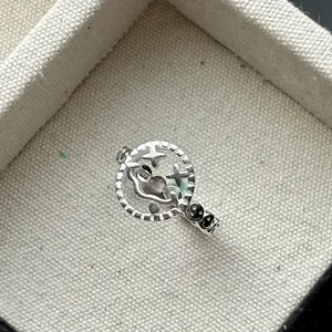 Gros plan détaillé d'une bague smiley évidée en argent sterling S925 avec yeux étoilés