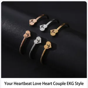 Primer plano de pulseras de acero inoxidable con forma de corazón y patrón de latido grabado