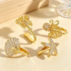 Detailed view of four ocean-themed non-pierced gold nose clips with sparkling zircon inlays