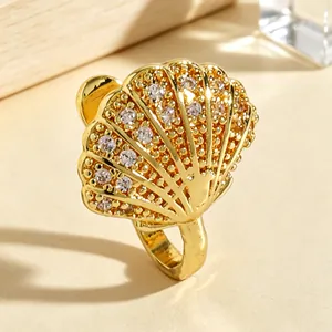 Exquisite macro detail of a gold-tone seashell-shaped nose clip with inlaid white zircons.
