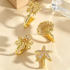 Detailed shot of ocean-themed gold non-piercing nose rings with sparkling zircons.