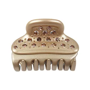 Detailed view of gold acetate hair claw clip with sparkling brown rhinestones