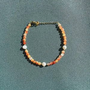 Vue détaillée d'un bracelet en pierre naturelle orange facettée avec des perles d'eau douce