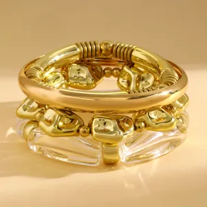 Detailed close-up of retro chunky gold-tone CCB beads and clear acrylic stacked bracelet set