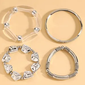 Detailed view of four assorted silver-toned and clear acrylic fashion bracelets.