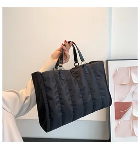Close-up detail of a stylish black quilted tote bag with elegant hand-held display for winter fashion
